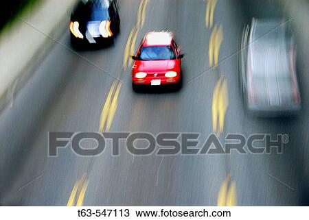 Red car on road ahead of other cars. View Large Photo Image Stock Image - Red car on road ahead of other cars.. Fotosearch