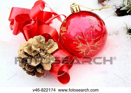 Red Christmas ball with gilt pine cone and red ribbon in snow A red transparent ball with gold glitter snowflake on it lies in snow next to a gilt pine cone Red satin ribbon curls about them High color contrast of elements and textures View Large Photo Image Picture - Red Christmas ball with gilt pine cone and red ribbon in snow A red transparent ball with gold glitter snowflake on it lies in snow next to a gilt pine cone Red satin ribbon curls about them High color contrast of elements and textures. Fotosearch