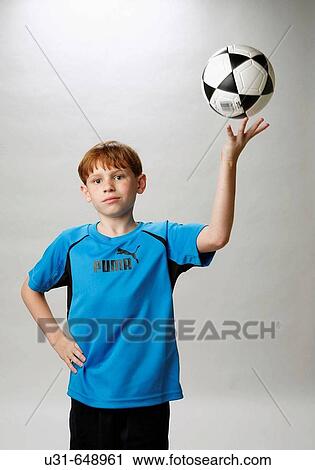 Stock Image - Red haired boy dominates a soccer ball. Fotosearch