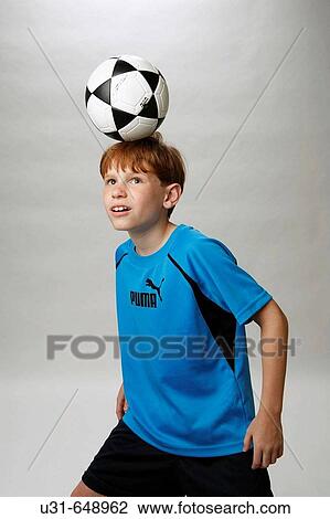Stock Image - Red haired boy dominates a soccer ball. Fotosearch