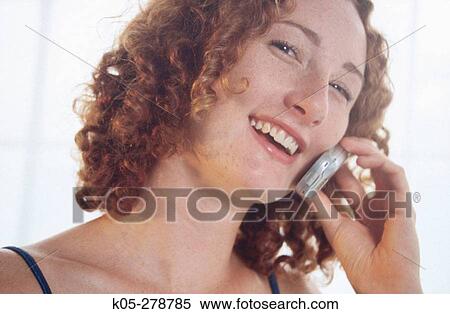 Red haired girl laughing while talking on mobile phone View Large Photo Image Stock Photography - Red haired girl laughing while talking on mobile phone. Fotosearch