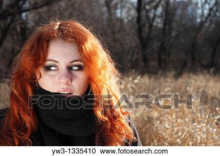 Stock Image - red haired girl outdoors in light of down. Fotosearch