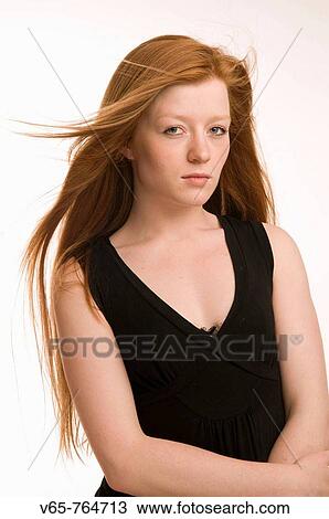 Stock Image - Red haired teenage girl wearing black dress. Fotosearch