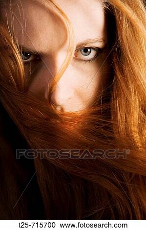 Stock Image - Red haired woman gazing at camera. Fotosearch