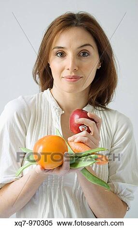 Stock Photography - Red-haired woman holding vegetables. Fotosearch
