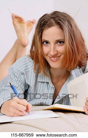 Red headed woman studying and taking notes on bed in pajamas View Large Photo Image Stock Photo - Red headed woman studying and taking notes on bed in pajamas. Fotosearch
