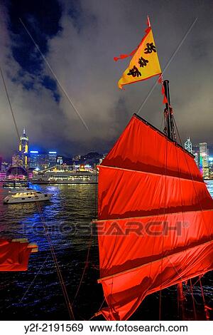 Red sail of iconic tour boat Aqua Luna, with boat and a cruise ship in Hong Kong harbour at night, against an office skyline View Large Photo Image Stock Photo - Red sail of iconic tour boat Aqua Luna, with boat and a cruise ship in Hong Kong harbour at night, against an office skyline. Fotosearch