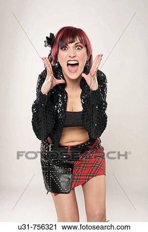 Stock Image - Redhaired rocker girl screaming at the camera. Fotosearch