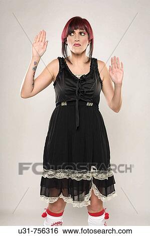 Redhaired trendy girl placing hands on imaginary glass window looking confused View Large Photo Image Stock Photograph - Redhaired trendy girl placing hands on imaginary glass window looking confused. Fotosearch