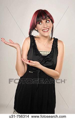Picture - Redhaired trendy girl signalling off camera. Fotosearch