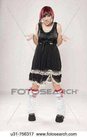 Stock Photo - Redhaired trendy girl wearing boots questioning at the camera. Fotosearch