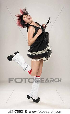 Stock Photo - Redhaired trendy girl wearing boots jumping. Fotosearch