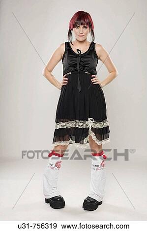 Redhaired trendy girl wearing boots looking bored at the camera View Large Photo Image Stock Photo - Redhaired trendy girl wearing boots looking bored at the camera. Fotosearch