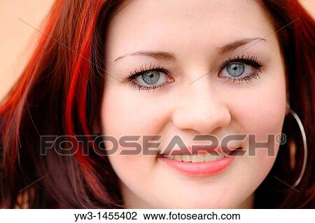 Stock Image - redhead women outdoors agains painted wall. Fotosearch