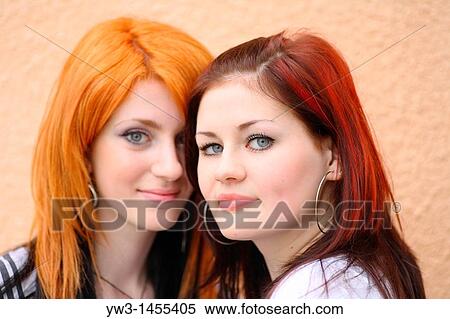 Stock Photography - redhead women outdoors in the street against wall. Fotosearch