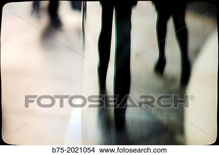 Picture - reflection in a glass of people legs walking down the street. Fotosearch