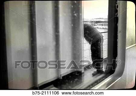 Reflection in a window of a passenger boat of a man leaning on the railing of the deck overlooking the sea. View Large Photo Image Stock Photograph - Reflection in a window of a passenger boat of a man leaning on the railing of the deck overlooking the sea.. Fotosearch