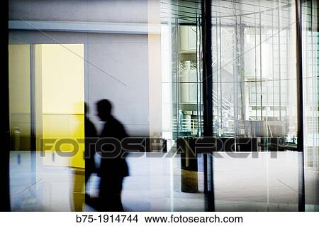 reflection of an executive walking down the hall of an office building in City of London, England, UK View Large Photo Image Picture - reflection of an executive walking down the hall of an office building in City of London, England, UK. Fotosearch