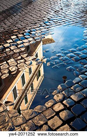 Reflection of house in rain puddle on cobbled street in Trastevere, Rome, Italy. View Large Photo Image Stock Image - Reflection of house in rain puddle on cobbled street in Trastevere, Rome, Italy.. Fotosearch