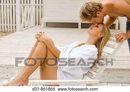 Relaxed woman receivin a kiss on her forehead View Large Photo Image Stock Photography - Relaxed woman receivin a kiss on her forehead. Fotosearch