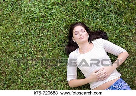 Stock Photo - Relaxing and listening to music on lawn. Fotosearch