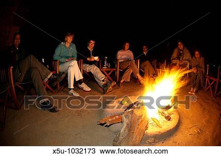 Stock Image - rElaxing around the camp fire at Kings Lodge, Bandhavgarh National Park, Madhya Pradesh, India 0207. Fotosearch
