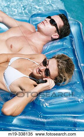 Stock Photography - relaxing in the pool talking on cel phone. Fotosearch