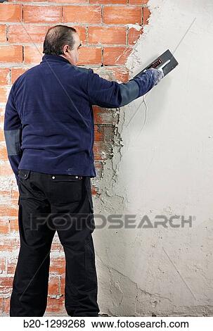 Rendering a brick wall using trowel, new homes under construction, construction site View Large Photo Image Stock Photo - Rendering a brick wall using trowel, new homes under construction, construction site. Fotosearch
