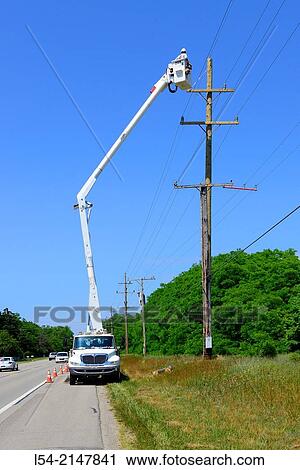 Stock Image - Repaimen fixing electrical wire.. Fotosearch