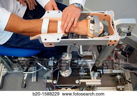 Stock Photo - Researcher placing a patient clinical training device of the limb has multiple modes of training wrist and arm. Fotosearch