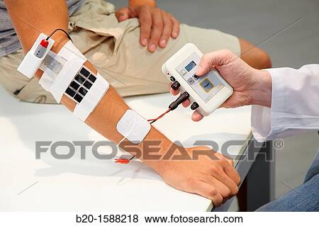 Stock Photo - Researcher placing multipad electrodes in the control arm for the stimulation model for sensor signals. Fotosearch