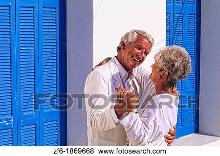 Retired healthy senior couple having fun dancing in the white buildings in beautiful Santorini Greece View Large Photo Image Stock Photo - Retired healthy senior couple having fun dancing in the white buildings in beautiful Santorini Greece. Fotosearch