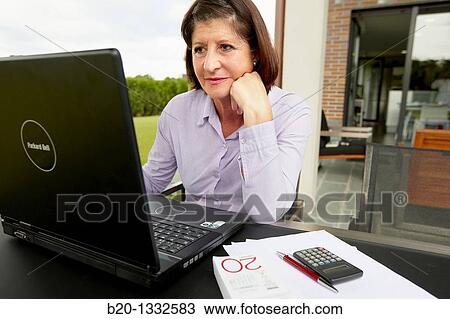 Retired woman using laptop computer in her garden View Large Photo Image Stock Image - Retired woman using laptop computer in her garden. Fotosearch