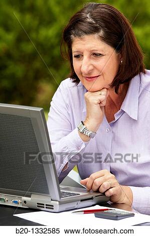 Retired woman using laptop computer in her garden View Large Photo Image Stock Photography - Retired woman using laptop computer in her garden. Fotosearch