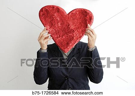 Retrato de mujer con corazon rojo tapando la cara, amor, Portrait of woman covering her face with a red heart, love, View Large Photo Image Picture - Retrato de mujer con corazon rojo tapando la cara, amor, Portrait of woman covering her face with a red heart, love,. Fotosearch