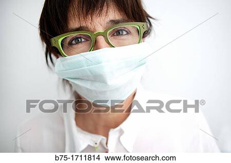Retrato de mujer de pelo moreno, ojos verdes, gafas y mascarilla tapando la boca, Portrait of brown-haired woman, green eyes, spectacles and a mask covering the mouth View Large Photo Image Picture - Retrato de mujer de pelo moreno, ojos verdes, gafas y mascarilla tapando la boca, Portrait of brown-haired woman, green eyes, spectacles and a mask covering the mouth. Fotosearch