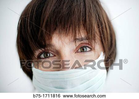 Retrato de mujer de pelo moreno, ojos verdes y mascarilla tapando la boca, Portrait of brown-haired woman, green eyes and a mask covering the mouth View Large Photo Image Stock Photograph - Retrato de mujer de pelo moreno, ojos verdes y mascarilla tapando la boca, Portrait of brown-haired woman, green eyes and a mask covering the mouth. Fotosearch