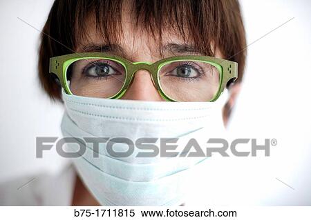 Retrato de mujer de pelo moreno, ojos verdes, gafas y mascarilla tapando la boca, Portrait of brown-haired woman, green eyes, spectacles and a mask covering the mouth View Large Photo Image Stock Photography - Retrato de mujer de pelo moreno, ojos verdes, gafas y mascarilla tapando la boca, Portrait of brown-haired woman, green eyes, spectacles and a mask covering the mouth. Fotosearch