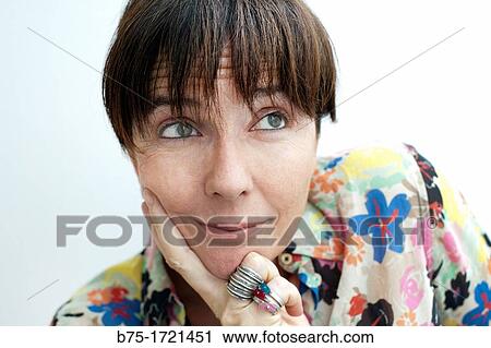 Stock Image - Retrato de mujer de pelo moreno y ojos verdes con expresion relajada, Portrait of brown-haired woman with green eyes and relaxed expression,. Fotosearch