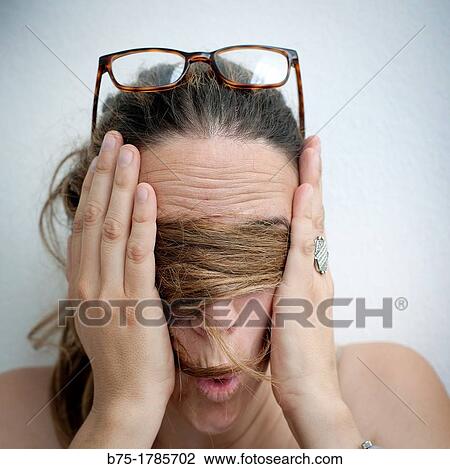 Retrato de mujer joven asustada con gafas en la cabeza, manos en la cara y pelo tapando los ojos, Portrait of frightened young woman with glasses on head, hands on the face and hair covering eyes, View Large Photo Image Stock Image - Retrato de mujer joven asustada con gafas en la cabeza, manos en la cara y pelo tapando los ojos, Portrait of frightened young woman with glasses on head, hands on the face and hair covering eyes,. Fotosearch