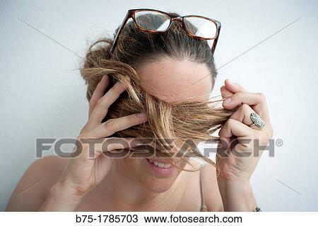 Retrato de mujer joven con gafas en la cabeza y pelo tapando los ojos, Portrait of young woman with sunglasses on her head and hair covering eyes, View Large Photo Image Stock Image - Retrato de mujer joven con gafas en la cabeza y pelo tapando los ojos, Portrait of young woman with sunglasses on her head and hair covering eyes,. Fotosearch