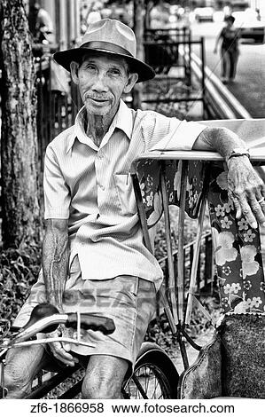 Rickshaw Driver in wealthy city and country of Singapore View Large Photo Image Stock Photo - Rickshaw Driver in wealthy city and country of Singapore. Fotosearch