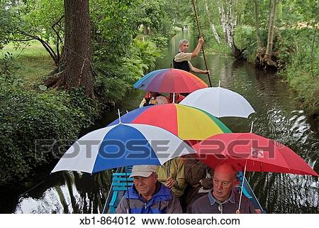 Stock Image - Ride with a typical Spreewald ship at rainy weather, Spreewald, district Oberspreewald-Lausitz, Brandenburg, Germany. Fotosearch