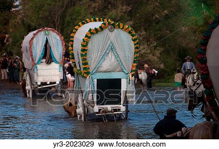 Riders and oxcarts of the Triana Brotherhood cross the Guadiamar's river ford, known as Vado del Quema, during the pilgrimage to the shrine of the Virgin of Rocio, in Aznalcazar, Sevilla province, Andalusia, Spain View Large Photo Image Stock Photo - Riders and oxcarts of the Triana Brotherhood cross the Guadiamar's river ford, known as Vado del Quema, during the pilgrimage to the shrine of the Virgin of Rocio, in Aznalcazar, Sevilla province, Andalusia, Spain. Fotosearch