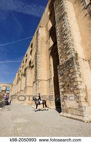 Stock Image - Riders crossing Amoreira aqueduct (16th-17th c. ), national monument, freguesia de Sao Bras e Sao Louren? o, Elvas municipality, Alentejo, Portugal. Fotosearch