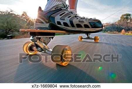 Picture - Riding the longboard skateboard on the Rock Creek Parkway in the city of Twin Falls in southern Idaho. Fotosearch