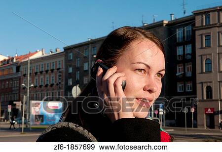 Riga Latvia modern woman on cell phone in downtown capital statue with scarf View Large Photo Image Stock Photo - Riga Latvia modern woman on cell phone in downtown capital statue with scarf. Fotosearch