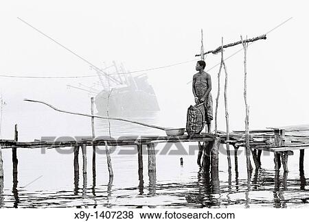 River Niger delta, Bendel State, Nigeria Woman on wooden jetty at Bennett Island Anchorage on the Warri River shipping channel View Large Photo Image Stock Photo - River Niger delta, Bendel State, Nigeria Woman on wooden jetty at Bennett Island Anchorage on the Warri River shipping channel. Fotosearch