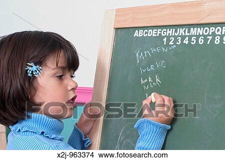 Picture - Riverview, Michigan - MaKenna Watt, 4, writes words on a blackboard in her bedroom. Fotosearch
