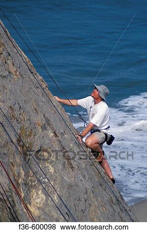 Rock climber climb cliff over ocean water waves at Point Dume State Beach near Malibu, Los Angeles County, California View Large Photo Image Stock Photo - Rock climber climb cliff over ocean water waves at Point Dume State Beach near Malibu, Los Angeles County, California. Fotosearch